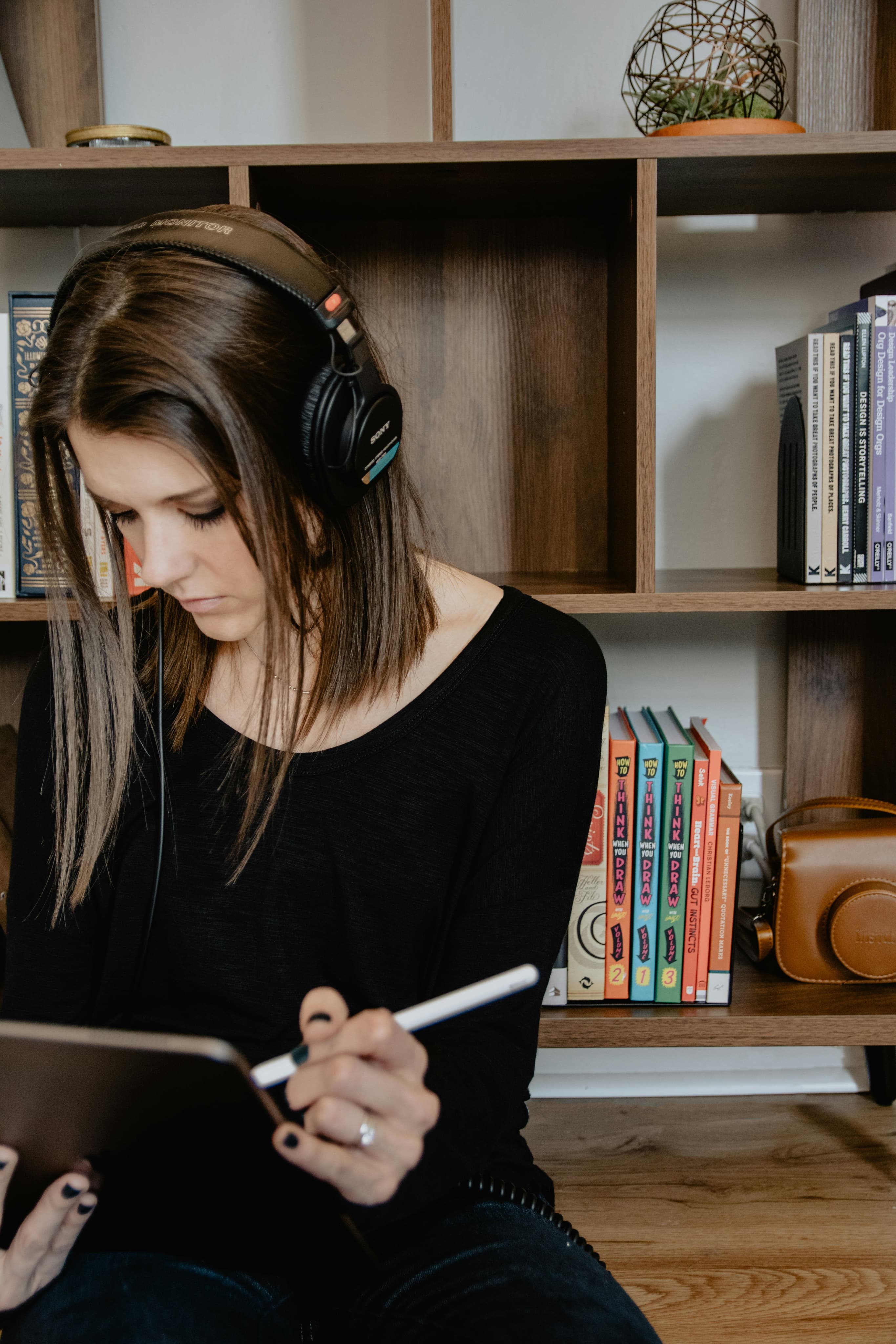Girl studying on iPad in front of a bookshelf